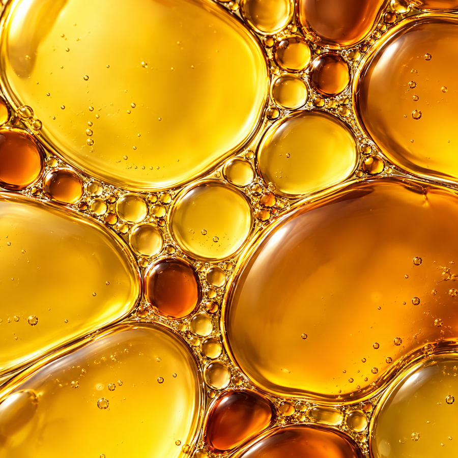 Golden botanical oil droplets in a macro photograph